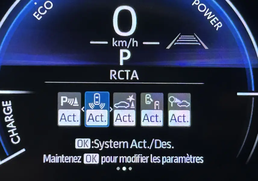 Tableau de bord numérique de Toyota Yaris Cross 130 Design blanc, affichant les aides à la conduite activées.