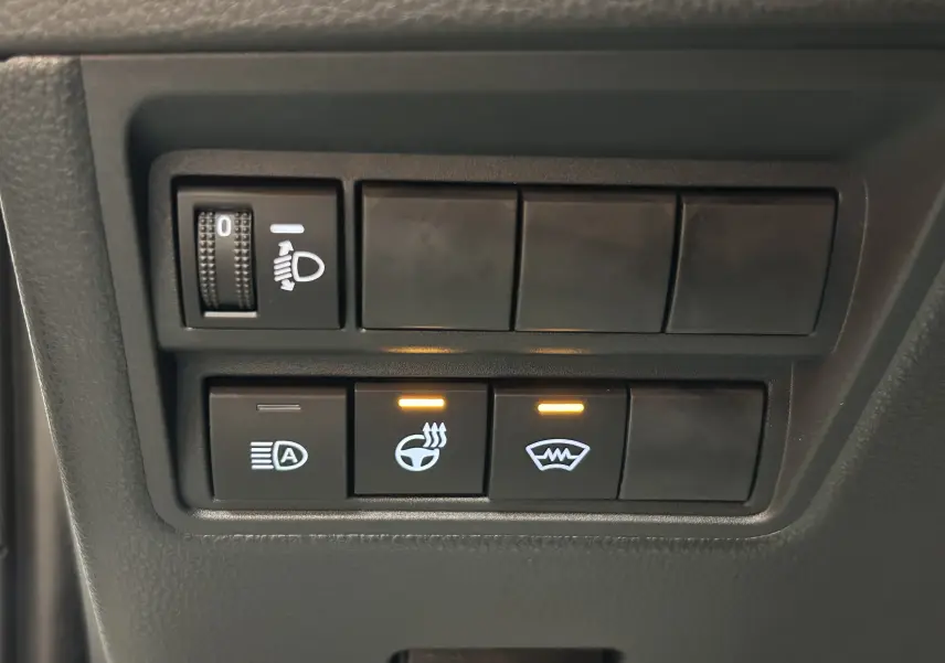 Gros plan sur les commandes chauffantes et d'aide à la conduite du Toyota Yaris Cross blanc 2025, version 130 DESIGN.