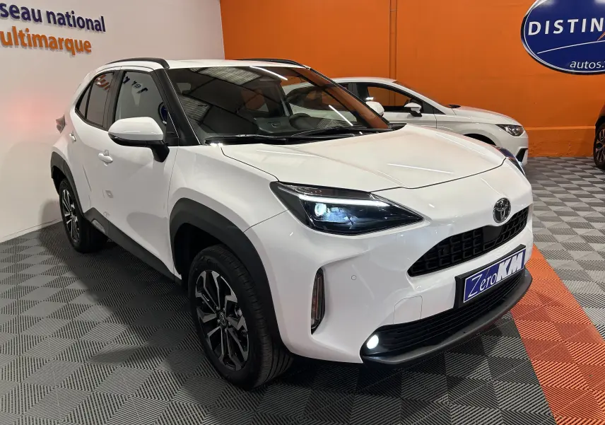 Toyota Yaris Cross 130 Design blanc vue 3/4 avant droit avec phares LED allumés et jantes noires distinctives