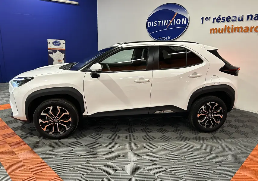 Profil latéral droit d'une Toyota Yaris Cross blanche 2025 avec jantes alliage et détails noirs contrastants.