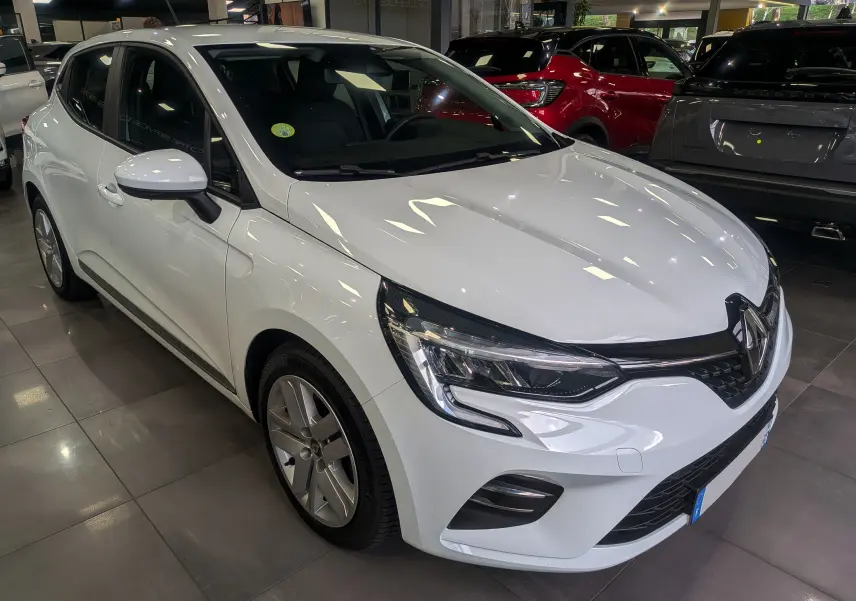 Renault Clio V Blue dCi 100 Business blanc glacier vue 3/4 avant droit en intérieur showroom.