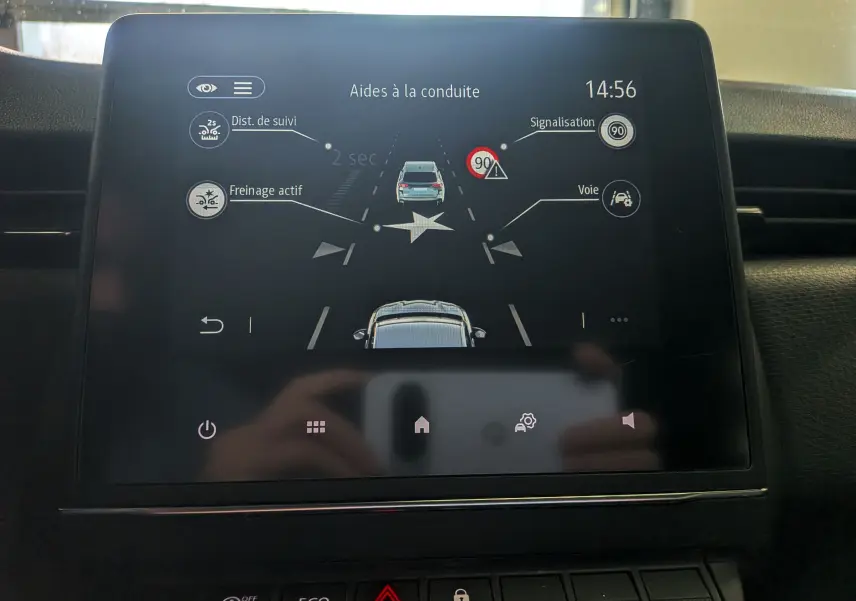 Écran tactile intérieur de Renault Clio V blanc montrant les aides à la conduite avec freinage actif et signalisation à 14h56