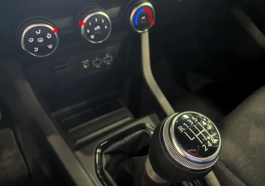 Gros plan sur le levier de vitesse manuel de la Renault Clio V Business 2021 avec commandes de climatisation en arrière-plan.