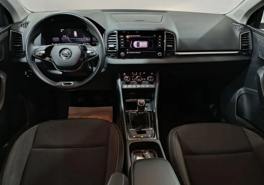 Intérieur noir du Skoda Karoq 2024, vue frontale du tableau de bord avec écran tactile et volant multifonctions.