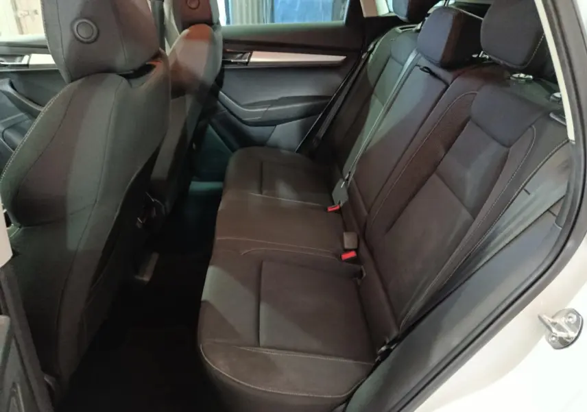 Vue côté droit de la banquette arrière noire du Skoda Karoq 2024 avec appuie-têtes et ceintures visibles.