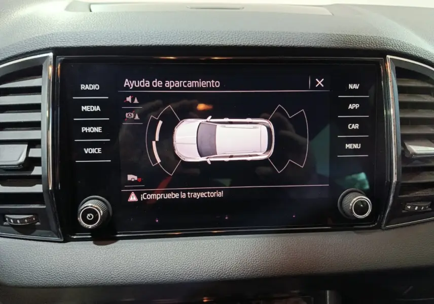 Écran tactile central montrant l'aide au stationnement du Skoda Karoq 2024, interface en espagnol.