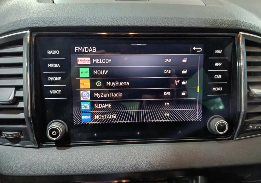Écran tactile central affichant les stations radio dans l'habitacle gris du Skoda Karoq 2024 diesel.