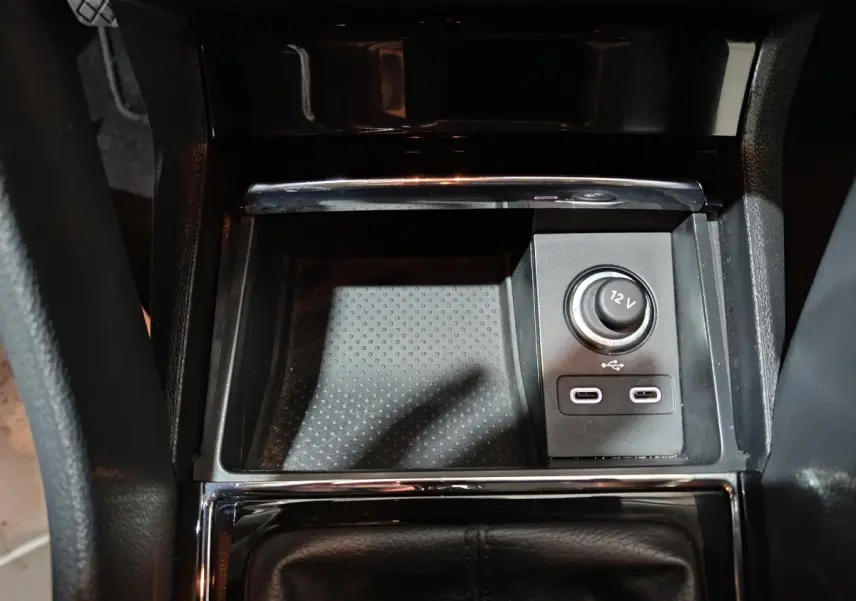 Gros plan sur la console centrale noire du Skoda Karoq 2024 avec prise 12V et deux ports USB-C.