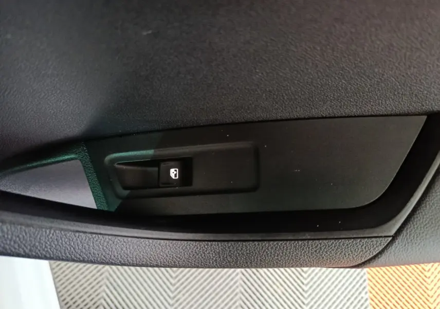 Gros plan sur l'interrupteur de fermeture électrique de coffre dans l'habitacle d'un Skoda Karoq 2024.