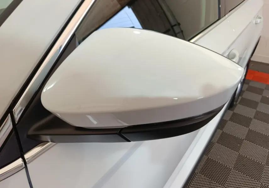 Rétroviseur côté gauche blanc du Skoda Karoq 2024, avec caméra intégrée et carrosserie blanche vue de près.