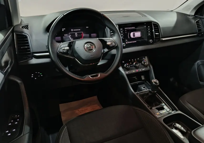 Intérieur noir du Skoda Karoq 2024, vue de face sur le volant cuir, tableau de bord digital et écran tactile central.