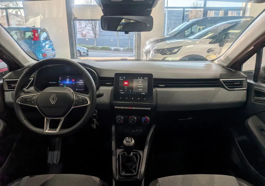 Vue intérieure avant de la Renault Clio V Orange Valencia, tableau de bord avec écran tactile et boîte manuelle.