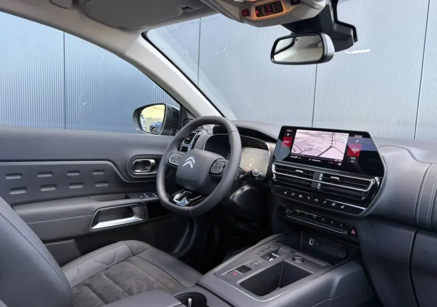 Intérieur avant droit du Citroën C5 Aircross 2025 avec tableau de bord noir, écran tactile et sièges Urban Black en Alcantara® noir.