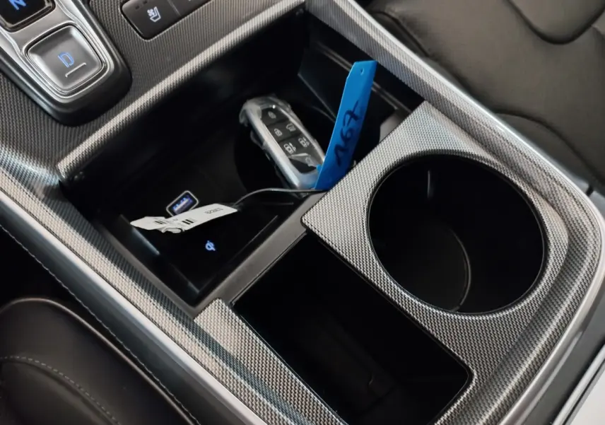 Vue rapprochée de la console centrale gris carbone du Hyundai Santa Fe hybride avec clé et ports USB visibles.