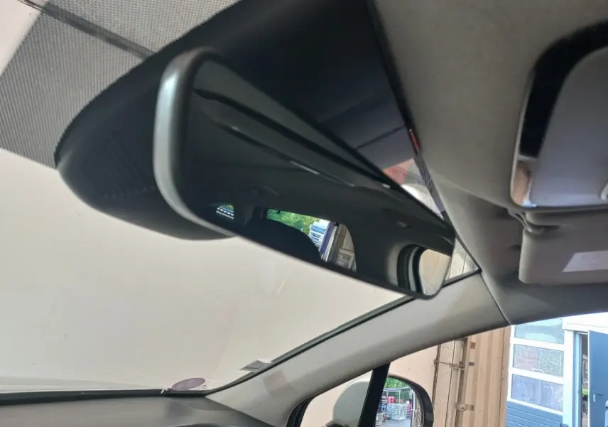 Vue intérieure du rétroviseur central du Hyundai Santa Fe gris clair 2021, avec reflet du toit et siège arrière.