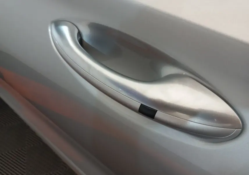 Poignée de porte côté droit gris clair du Hyundai Santa Fe hybride rechargeable 2021, finition lisse avec bouton noir intégré.