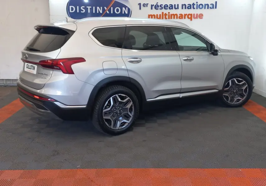 Vue latérale droite d’un Hyundai Santa Fe gris clair hybride rechargeable, avec jantes alliage et toit ouvrant électrique.