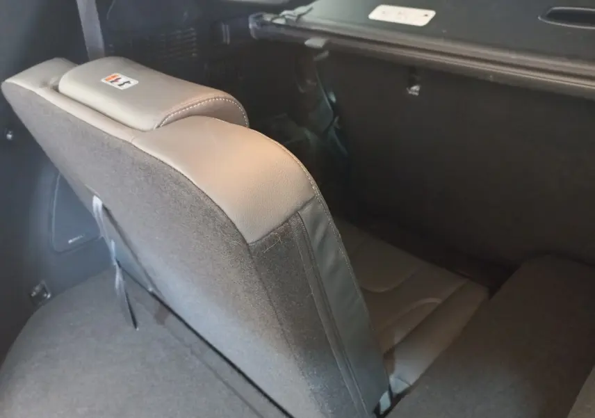 Vue rapprochée de la troisième rangée de sièges rabattus en cuir gris dans le coffre du Hyundai Santa Fe hybride 2021.