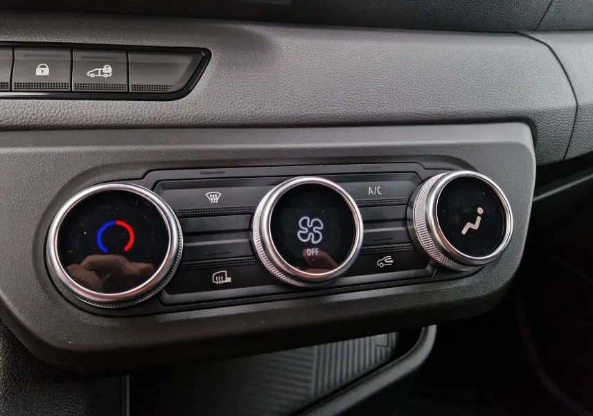 Gros plan sur les commandes de climatisation du tableau de bord du Renault Master L2H2 gris urbain, année 2026.
