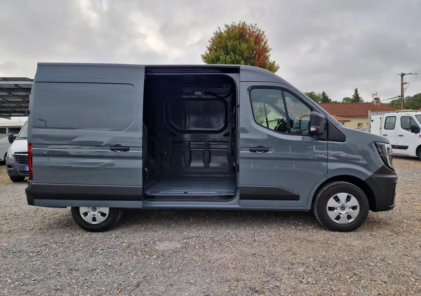 Renault Master L2H2 gris urbain vu de profil droit, porte latérale coulissante ouverte montrant l’espace de chargement vide.