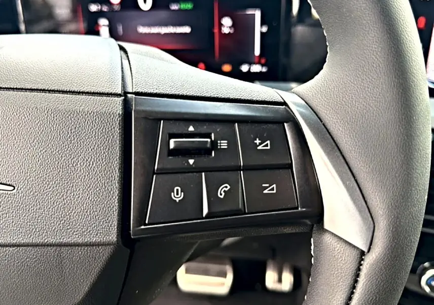 Gros plan sur les commandes noires du volant côté gauche de l’Opel Mokka Electric 156 gs 2025.
