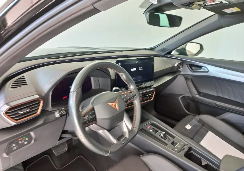 Intérieur du CUPRA Formentor 2024 vu côté conducteur, avec volant multifonction et écran tactile central.