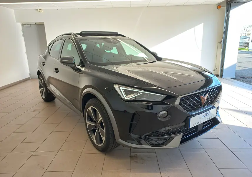 Vue 3/4 avant du CUPRA Formentor noir minuit avec jantes 18 pouces et toit ouvrant panoramique visible en intérieur showroom.