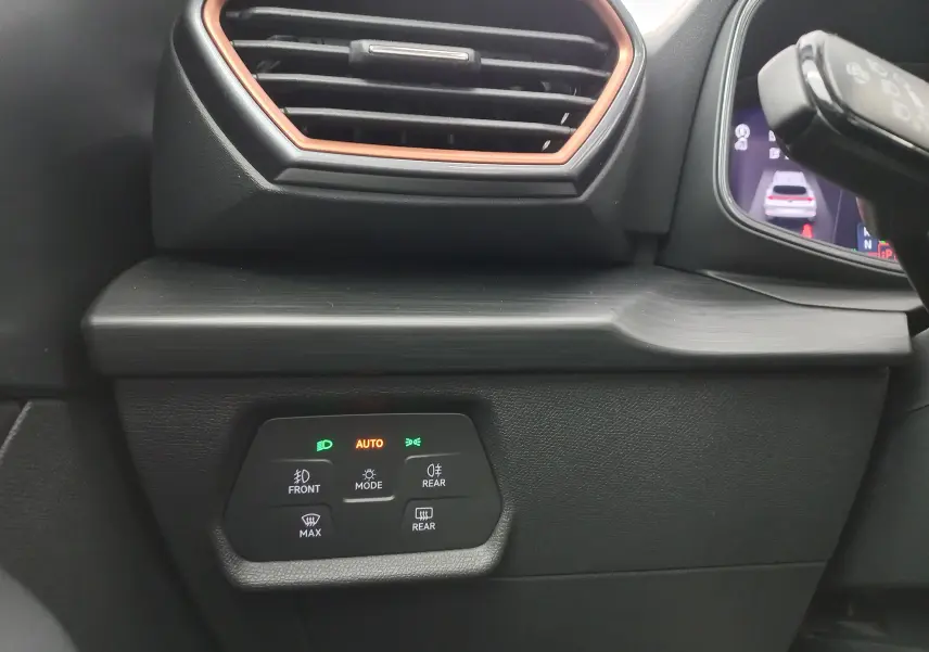 Détail intérieur du tableau de bord côté gauche du CUPRA Formentor 1.4 e-HYBRID 2024 avec commandes d’éclairage et aérateur à contour cuivré.