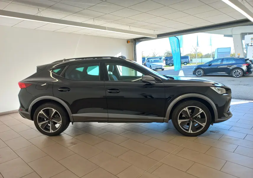 Vue de profil côté gauche du CUPRA Formentor noir minuit avec jantes alliage 18'' Performance Aero dans un showroom.