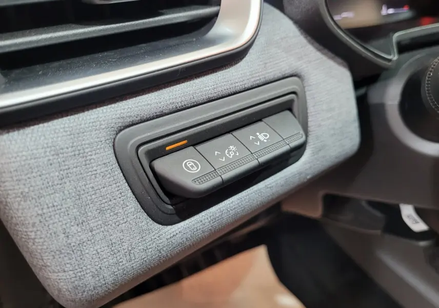 Gros plan sur les commandes d'éclairage et tableau de bord en tissu gris clair de la Renault Clio Evolution Blue dCi 100 2025.