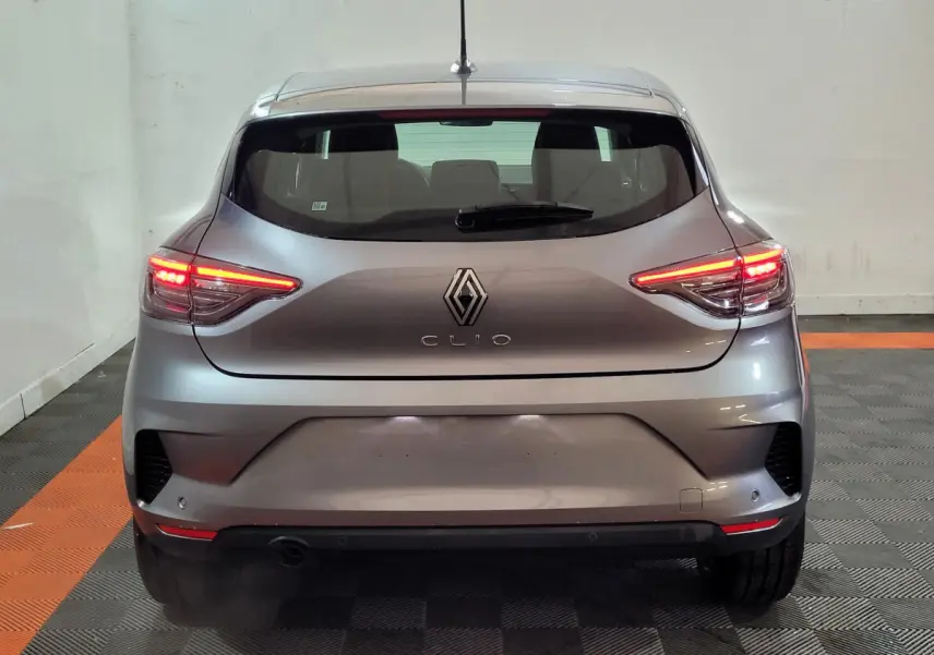 Vue arrière d'une Renault Clio gris foncé 2025 avec feux LED allumés dans un garage.