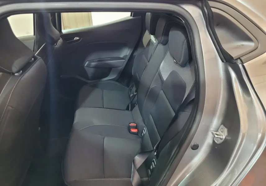 Vue intérieure sur la banquette arrière noire de la Renault Clio gris foncé Evolution Blue dCi 2025, porte ouverte côté droit.
