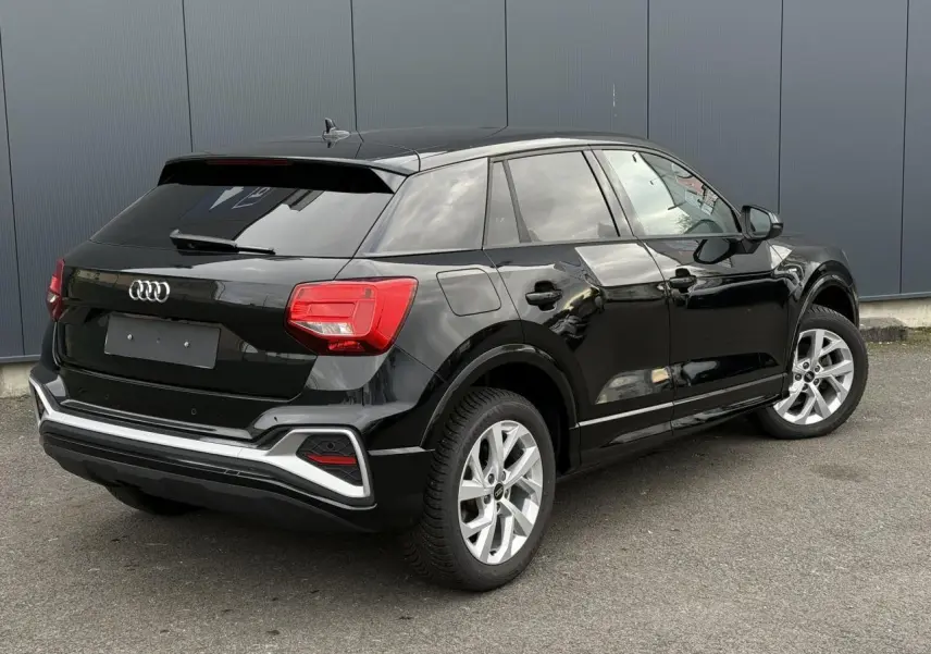 Audi Q2 noir Mythe vue 3/4 arrière droit, avec feux LED et jantes alliage 17 pouces visibles.