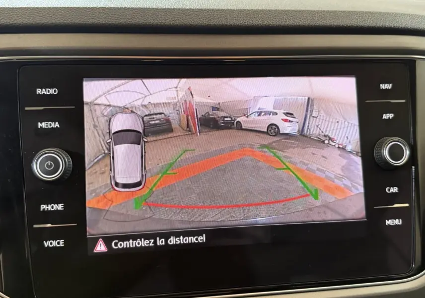 Vue de l'écran tactile du Volkswagen T-Roc noir montrant la caméra de recul avec guidage de trajectoire coloré.