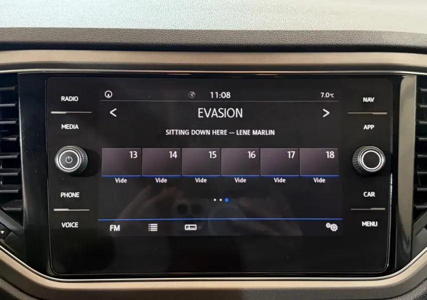 Écran tactile central du tableau de bord du Volkswagen T-Roc noir, affichant une station radio FM à 11h08.