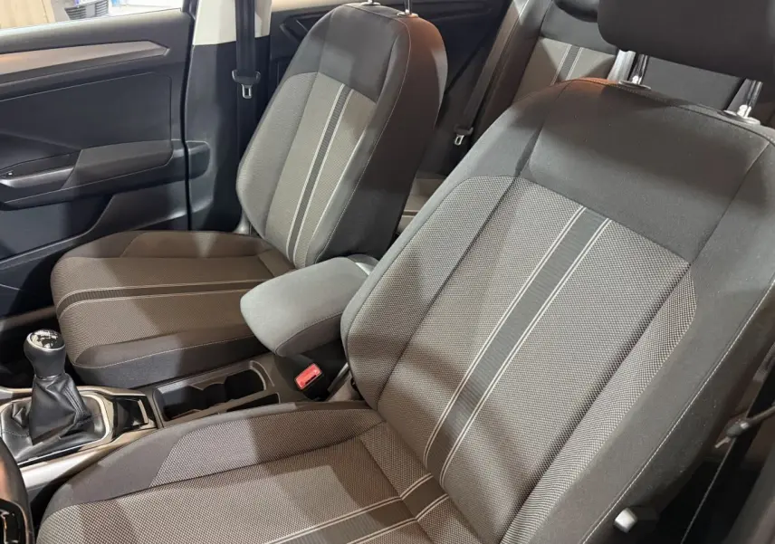 Vue intérieure côté conducteur du Volkswagen T-Roc 2020, sièges tissu gris avec bandes centrales claires et levier de vitesses manuel.