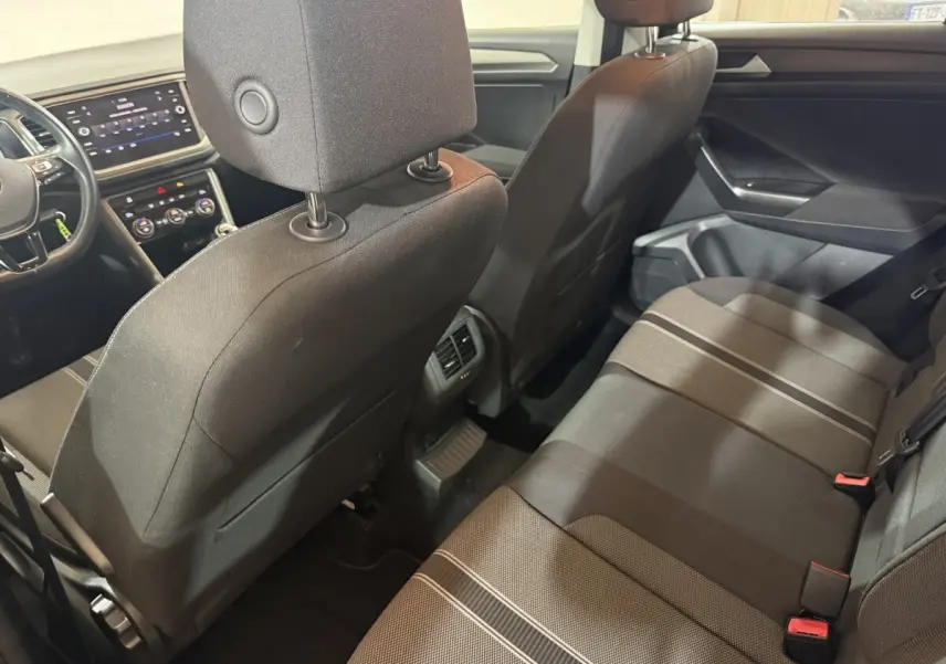 Vue intérieure arrière du Volkswagen T-Roc noir 2020, montrant les sièges arrière et la console centrale avec aérateurs.