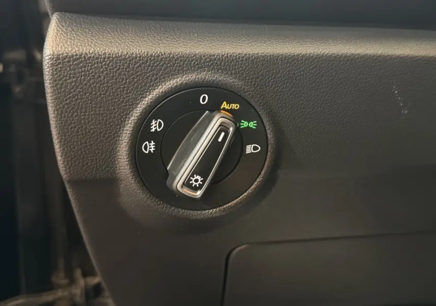 Gros plan sur le bouton de commande des phares du tableau de bord noir du Volkswagen T-Roc 2020 version Lounge Business.