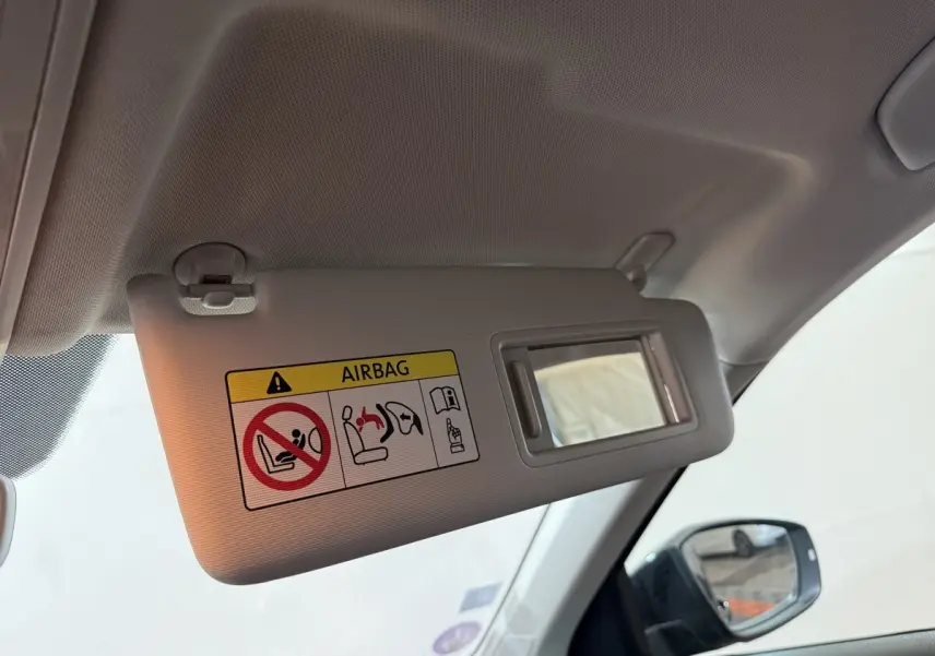 Détail du pare-soleil côté conducteur avec miroir et avertissement airbag dans un Volkswagen T-Roc noir 2020.