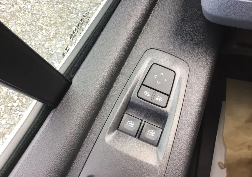 Gros plan sur les commandes électriques des vitres et rétroviseurs côté conducteur du Renault Master blanc 2026.