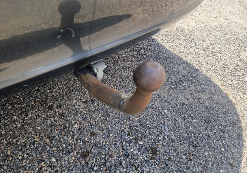 Gros plan sur la boule d'attelage rouillée sous le pare-chocs arrière d'une Peugeot 508 SW gris shark.