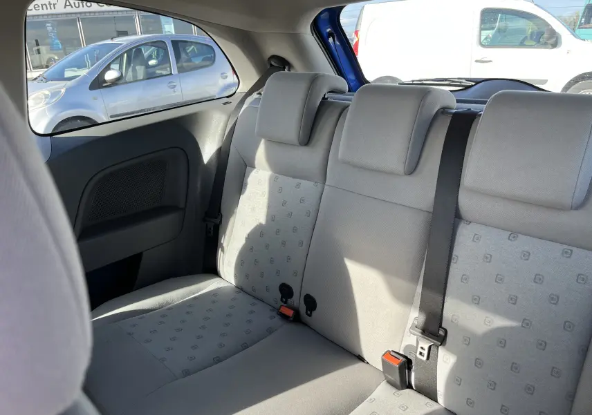 Vue intérieure sur la banquette arrière grise de la Ford Fiesta 3 portes bleu, avec appuie-têtes et ceinture de sécurité noire.