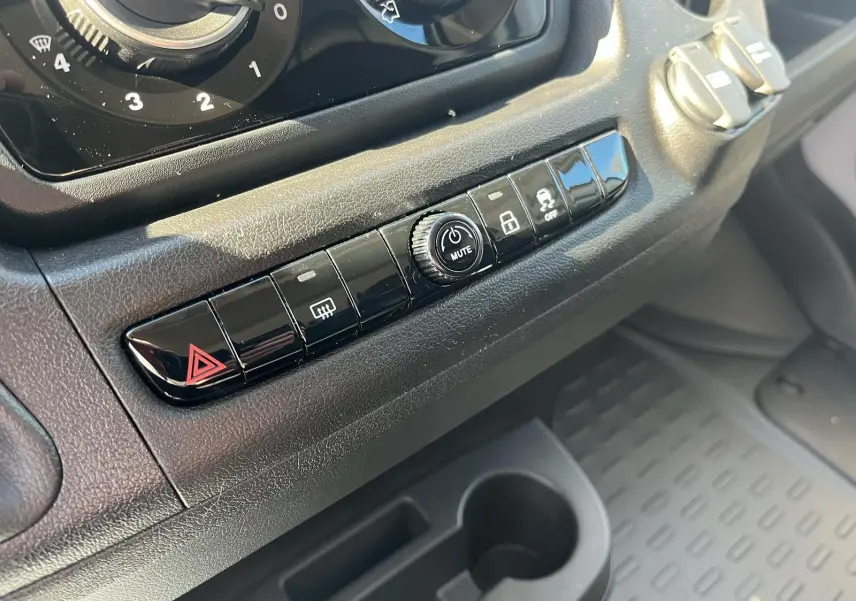 Gros plan sur la rangée de boutons noirs du tableau de bord du Fiat Ducato Fourgon blanc, 2023.