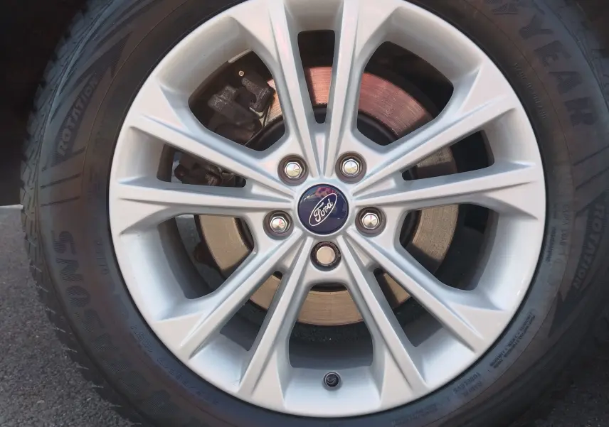 Gros plan sur la jante alliage argentée avec logo Ford central du Ford Kuga gris clair 2019.