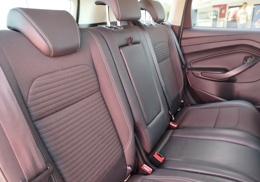 Vue intérieure sur la banquette arrière en cuir noir avec surpiqûres blanches du Ford Kuga gris clair 2019.