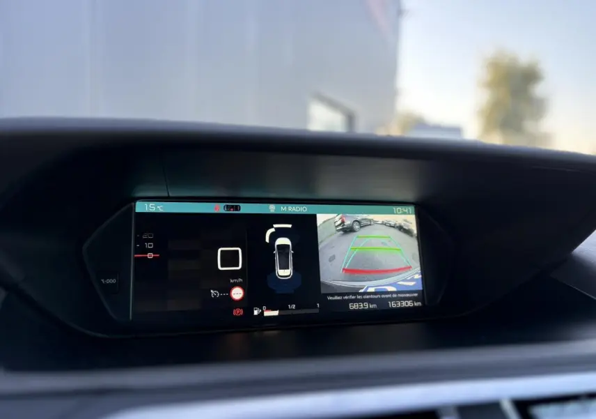 Écran de tableau de bord de Citroën C4 Picasso gris Platinium montrant la caméra de recul et les aides à la conduite.