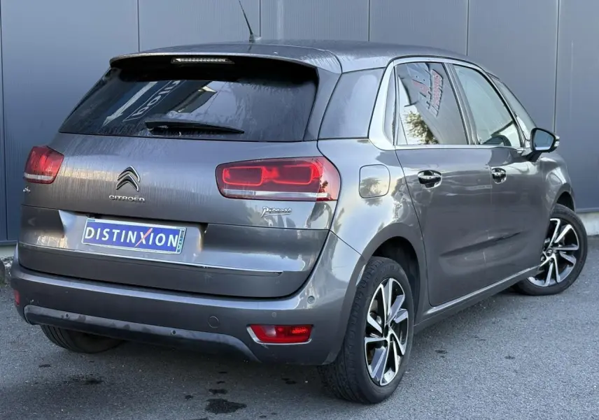 Vue 3/4 arrière droite d'une Citroën C4 Picasso gris Platinium avec feux arrière LED et jantes alliage bi-ton.