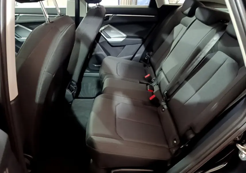 Vue latérale intérieure des sièges arrière noirs de l'Audi Q3 35 TDI 150 S tronic Business Line de 2020.