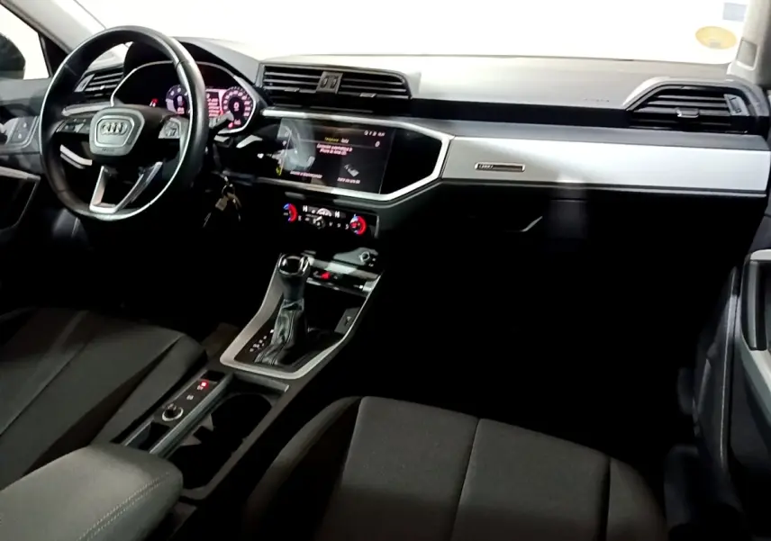 Intérieur noir de l'Audi Q3 35 TDI 2020 vu côté conducteur, avec tableau de bord digital et console centrale moderne.