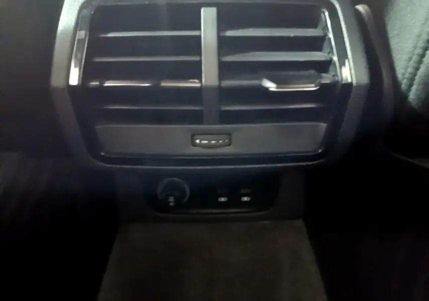 Gros plan sur la sortie d'air arrière noire et les commandes de charge USB du coffre de l'Audi Q3 35 TDI 2020.